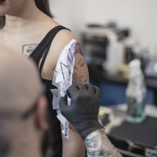 tattooist-removing-tattoo-stencil-from-woman-s-arm-2024-07-01-19-14-09-utc-scaled